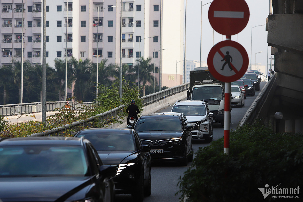 Đến 17h, nút giao Nghiêm Xuân Yêm hướng đi quận Thanh Xuân xảy ra ùn tắc. Ô tô lưu thông từ Vành đai 3 trên cao xuống nút giao này gặp khó khăn. Đáng nói, nhiều ô tô đón, trả khách trên Vành đai 3 trên cao khiến người đi bộ và xe máy đi lại lộn xộn. (Ảnh Vietnamnet)