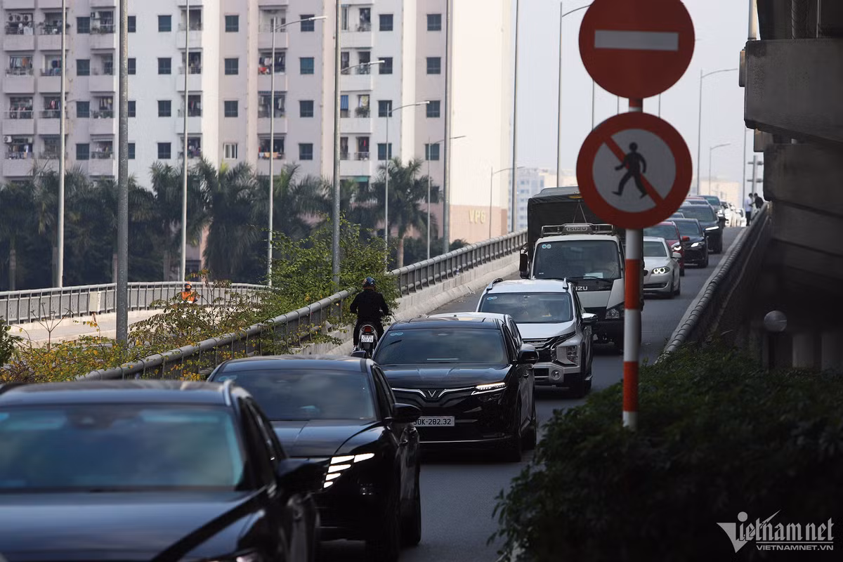 Đến 17h, nút giao Nghiêm Xuân Yêm hướng đi quận Thanh Xuân xảy ra ùn tắc. Ô tô lưu thông từ Vành đai 3 trên cao xuống nút giao này gặp khó khăn. Đáng nói, nhiều ô tô đón, trả khách trên Vành đai 3 trên cao khiến người đi bộ và xe máy đi lại lộn xộn. (Ảnh Vietnamnet)