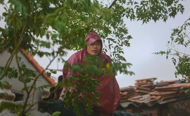 Một người dân với ánh mắt chờ đợi ngồi trên nóc nhà. (Ảnh: Soha).