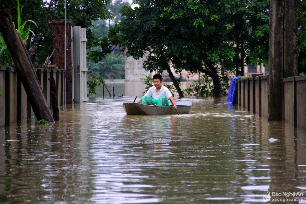 Tại những điểm ngập nặng, người dân phải di chuyển bằng thuyền. Ảnh Báo Nghệ An. 
