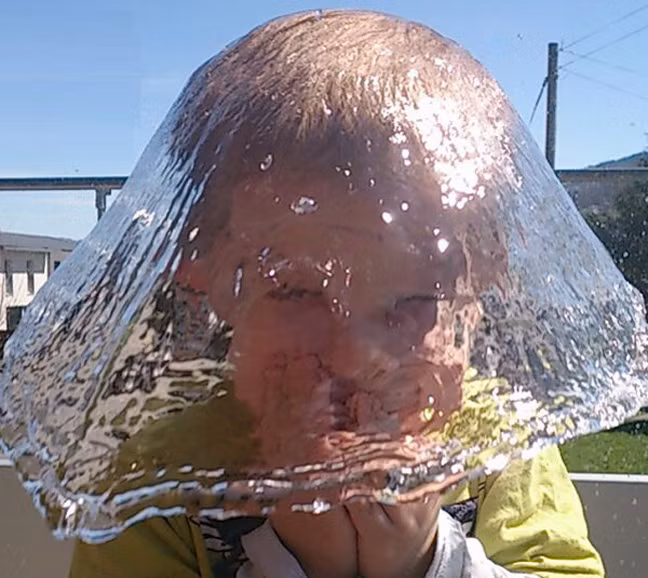 Hoàn hảo đến mức ngạc nhiên, khoảnh khắc trước khi những hạt nước rơi xuống đất tạo thành chiếc nón làm bằng nước của cậu bé này khiến nhiều người không tin nổi vào mắt mình. (Nguồn Sina)