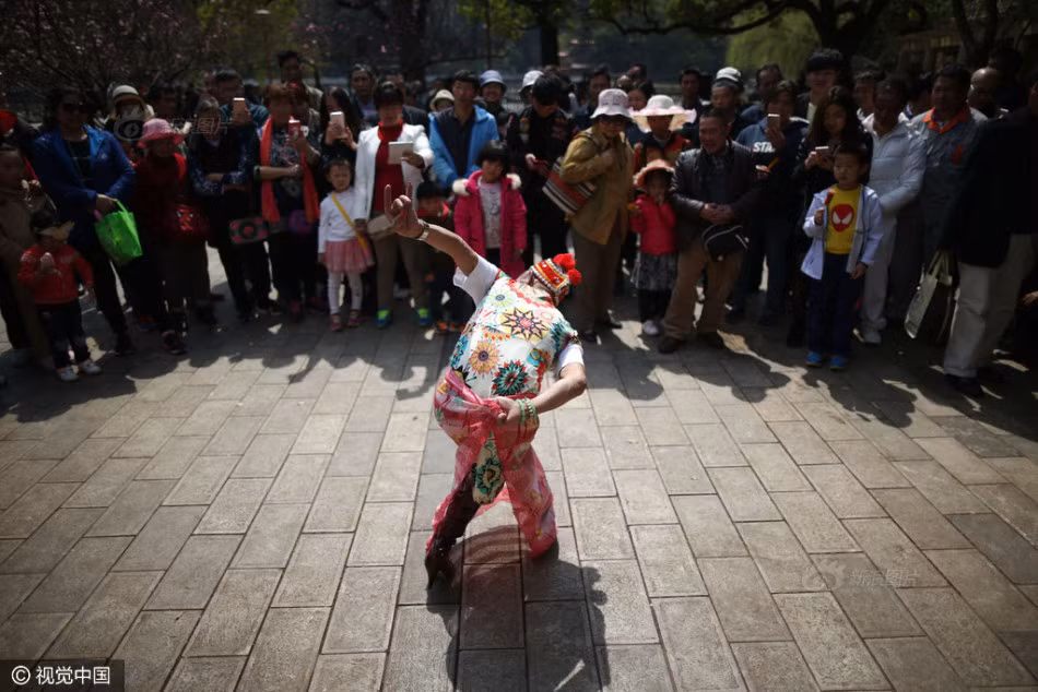 Không chỉ ăn mặc khác người, dị nhân 74 tuổi này còn nhảy múa, ca hát rất nhiết tình, thu hút được đông đảo sự chú ý của mọi người. (Nguồn Sina)