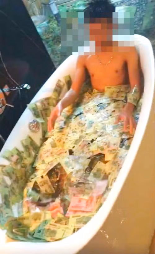  6. “Thiếu gia” Việt rải đầy tiền vào bồn tắm Tháng 6/2016, một đoạn clip được ghi lại trong nhà tắm và nhân vật chính là một “chàng thiếu gia” đang thoải mái vùng vẫy trong chiếc bồn tắm rộng rãi của mình. Điều đáng nói là trong chiếc bồn tắm đó có rải đầy tiền với các mệnh giá lớn khác nhau. Ảnh: phapluatso.