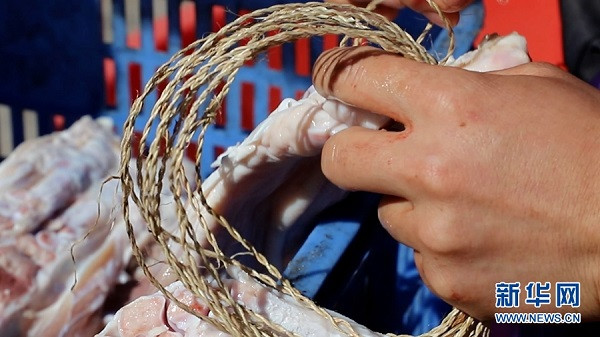 Dân làng đang móc dây vào thịt để chuẩn bị phơi.