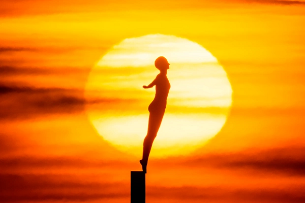 Sắc vàng óng ánh của mặt trời chào ngày mới tạo nên hoàn hảo cho bức tượng Diving Belle ở Scarborough, North Yorks. Ảnh: The Sun