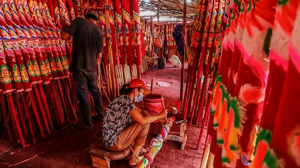 Những cây hương này được làm từ bột gỗ và keo dán, sau đó cuộn chặt rồi phơi dưới nắng nhiều tháng trước khi nhuộm đỏ và vẽ trang trí.