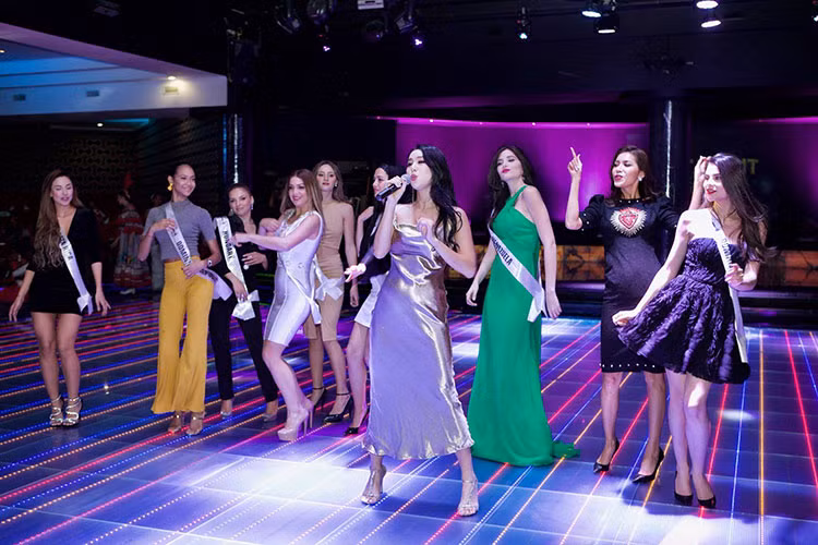  Đại diện Việt Nam Minh Tú tiếp tục ghi điểm khi giúp đại diện Venezuela đeo lại dải băng bị rơi.