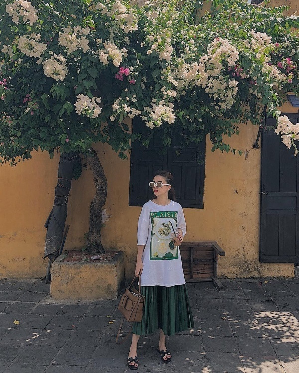 Yến Trang cũng là mỹ nhân có gu thời trang sành điệu đậm chất fashionista của mình. Và đặc biệt, nghía qua trang cá nhân của cô có thể thấy sự xuất hiện của những items giá rẻ. Phối áo phông cùng chân váy midi, Yến Trang đã tạo nên một bộ trang phục thanh lịch, thoải mái. Được biết, mẫu áo phông dáng dài có giá hơn 500 nghìn đồng còn chân váy xếp ly phủ sắc lá cây trị giá hơn 1 triệu đồng. Cả 2 thiết này đều đến từ thương hiệu Zara.