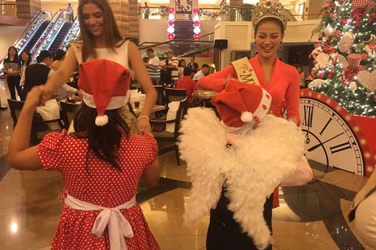 Tân hoa hậu nhảy múa cùng các em nhỏ trong lễ thắp sáng cây thông Noel.