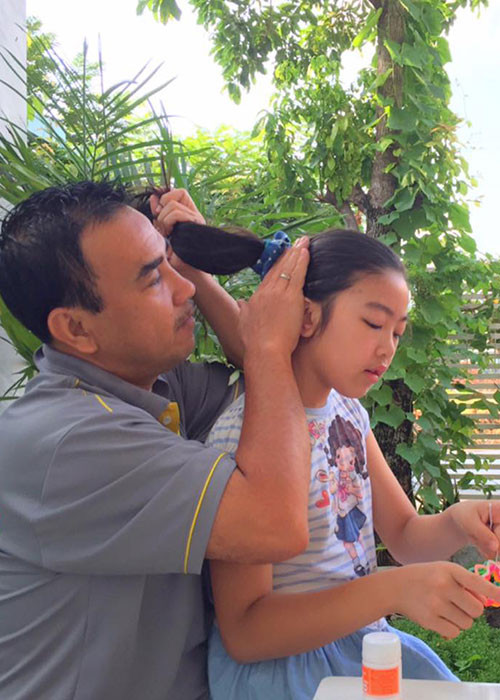 Hình ảnh Quyền Linh khéo buộc tóc cho con gái.