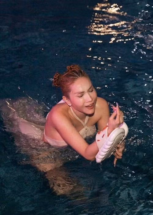 Khả Như cố gắng giữ lấy đôi dép sau khi bị ném xuống nước. Ảnh: FBNV