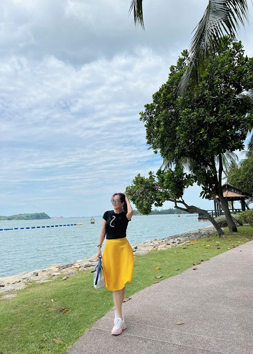 Bà xã Bình Minh lựa chọn set trang phục chân váy cạp cao, áo body tôn được vóc dáng thon gọn.