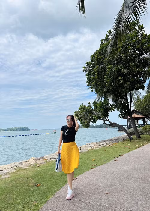 Bà xã Bình Minh lựa chọn set trang phục chân váy cạp cao, áo body tôn được vóc dáng thon gọn.