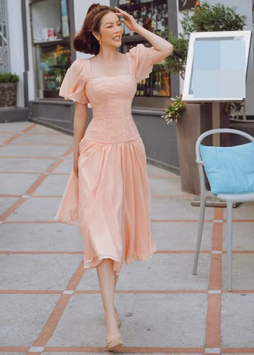 Nữ diễn viên khoe vẻ trẻ trung ở tuổi 40 khi diện chiếc váy gam cam đào.