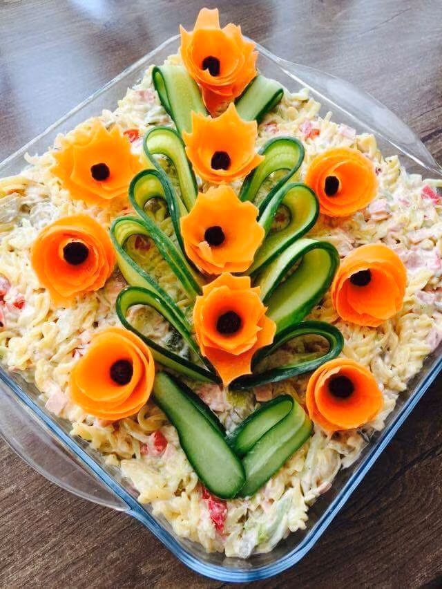 Tỉa hoa cà rốt và thái lát mỏng dưa chuột xếp hình cái cây lên trên khay salad Nga cũng là gợi ý dễ thực hiện.