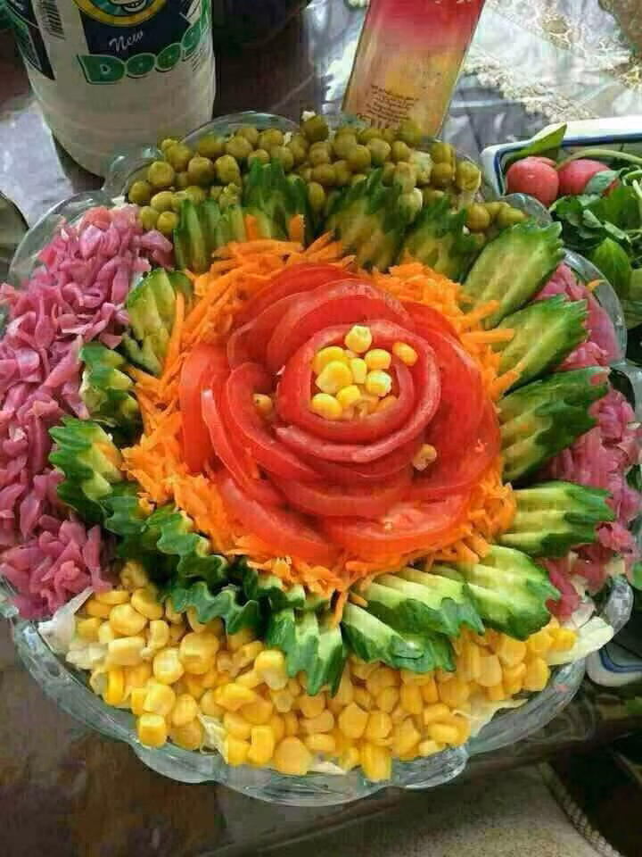 Một đĩa salad được trình bày như bông hoa với các cánh có màu khác nhau.