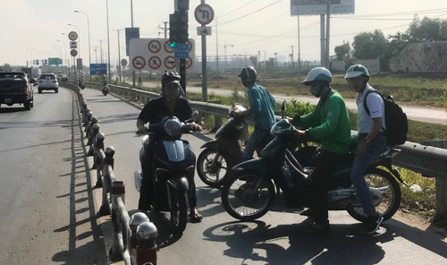 Tình trạng hỗn loạn giao thông khi rất nhiều người đi xe máy nháo nhào quay đầu xe chạy ngược chiều trên đường dẫn cao tốc vì nút giao bị đóng.