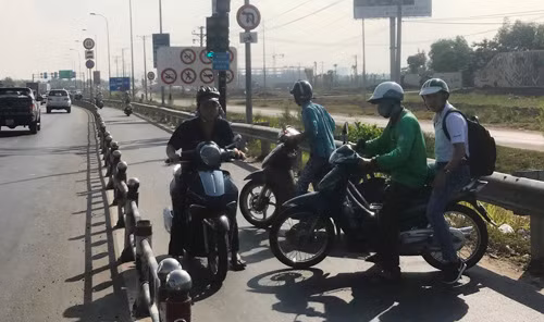 Tình trạng hỗn loạn giao thông khi rất nhiều người đi xe máy nháo nhào quay đầu xe chạy ngược chiều trên đường dẫn cao tốc vì nút giao bị đóng.