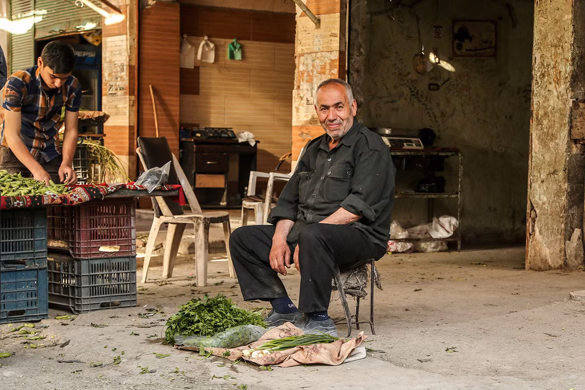 Người đàn ông lớn tuổi mang rau ra bán ở thị trấn Syria bị bao vây.