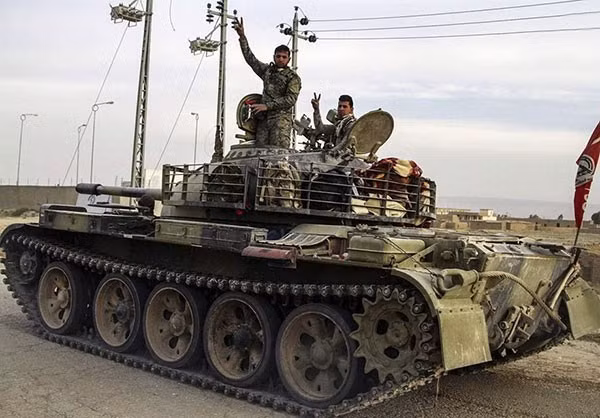 Ê-kíp lái xe tăng giơ dấu hiệu chiến thắng khi họ hân hoan đổ về Qayrawan. Nguồn ảnh FNA.