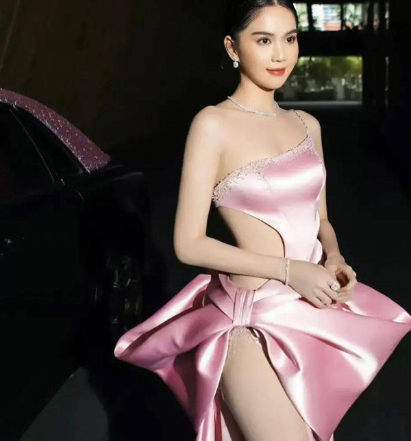 Ngay cả khi chọn trang phục cắt xẻ, đầm hồng vẫn giúp Ngọc Trinh được khen hết lời. Trong hình, bộ đồ với điểm nhấn là chiếc nơ to bản. Chất liệu satin cao cấp giúp vẻ ngoài trở nên quý phái, sexy, khoe triệt để nước da trắng mịn cùng vòng eo săn chắc.