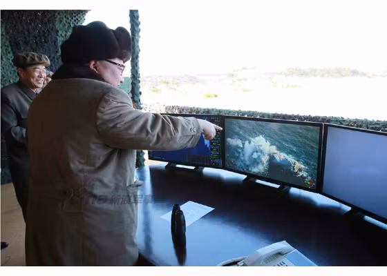 Trong ảnh là nhà lãnh đạo Kim Jong-un chỉ đạo cuộc tập trận bắn đạn thật trên đài quan sát với các màn hình ghi lại hình ảnh cuộc bắn và khoảnh khắc mục tiêu bị đánh trúng.