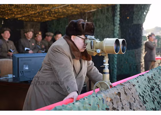 Ảnh: Ông Kim Jong-un theo dõi cuộc bắn bằng kính quang học.