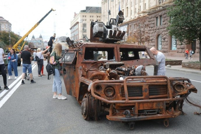 Người dân Ukraine xếp hàng chụp ảnh cạnh những chiếc xe, trong khi trẻ em được phép leo trèo thoải mái bên trong và trên nóc xe.