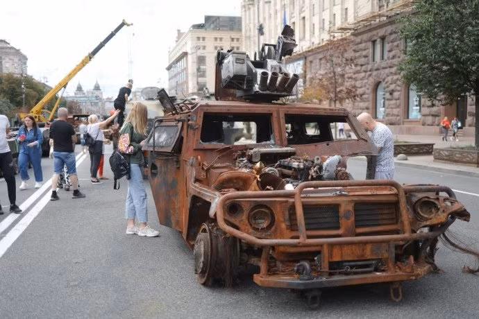 Người dân Ukraine xếp hàng chụp ảnh cạnh những chiếc xe, trong khi trẻ em được phép leo trèo thoải mái bên trong và trên nóc xe.