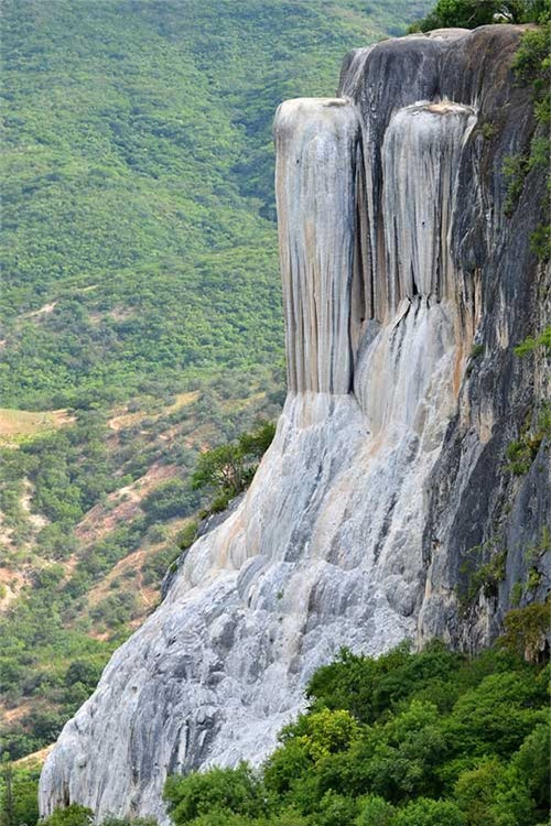 13. Thác Hierve el Agua, Mexico. Hierve el Agua là một vách đá tự nhiên ở bang Oaxaca và trông giống như một thác nước đang chảy. Khu vực này bao gồm 2 vách đá có độ cao 50 và 90m tính từ thung lũng phía dưới. Vách đá được hình thành bởi một lượng nhỏ nước bão hòa cacbonat canxi chảy ra từ các khe nứt. Nước ở đây có nhiệt độ trung bình là 22 đến 27 độ C. Khi nước chảy xuống bề mặt đá, nó tạo thành những nhũ đá lớn như trong hang động. Dòng chảy của nước ở đây thay đổi theo mùa và mạnh nhất là vào mùa xuân. Nước ở đây có hàm lượng khoáng chất cao và có tác dụng chữa bệnh rất tốt.