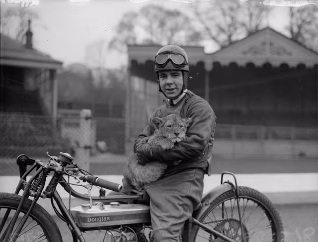 Người đàn ông lái mô tô ôm một con sư tử con ở London năm 1930.