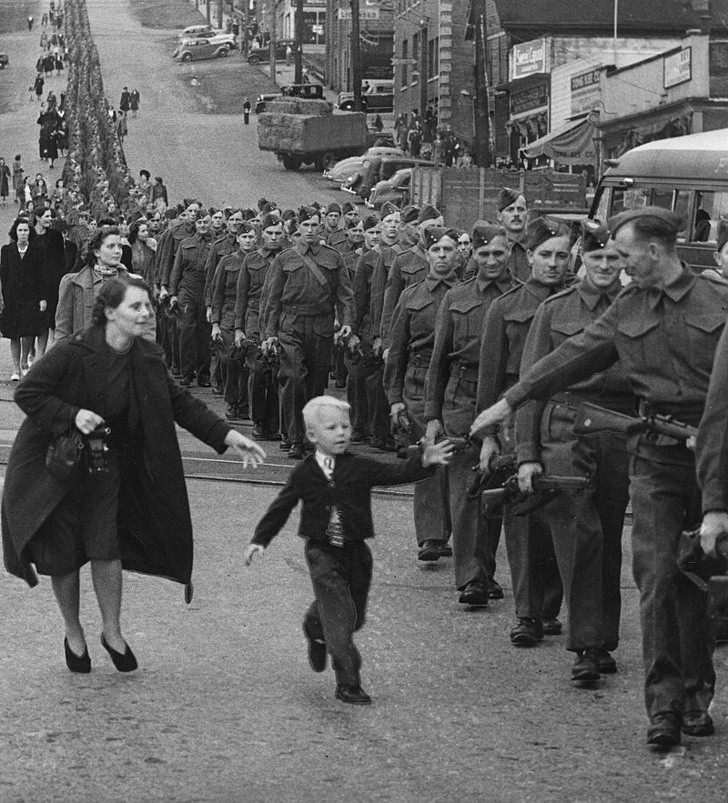  Bức ảnh lịch sử "Chờ con với, bố ơi" của Claude P. Dettloff chụp tại New Westminster, Canada ngày 1/10/1940. Bức hình khiến nhiều người nhói lòng với hình ảnh một bé trai cùng mẹ cố chạy theo để được nắm tay cha trước khi ông ra chiến trường ngày 1/10/1940.