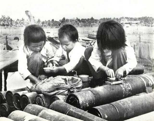 Ba đứa trẻ chơi đùa với những ống đựng đạn pháo ngày 27/1/1973.