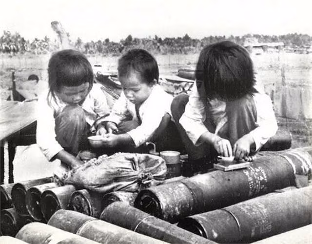 Ba đứa trẻ chơi đùa với những ống đựng đạn pháo ngày 27/1/1973.