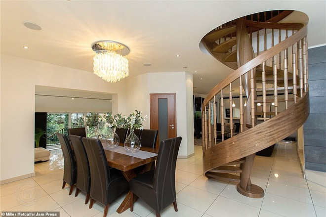 Bàn ăn bên cạnh cầu thang gỗ xoắn ốc.