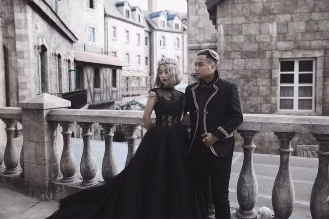 Khánh Chi yêu thích màu đen, gam màu của sự kiêu sa, lạnh lẽo, vậy nên cô nàng đã chẳng chút ngại ngần lựa chọn bộ váy cưới ren đen, khoét sâu táo bạo sau lưng để sánh đôi cùng chú rể trong bộ ảnh cưới kỳ bí của họ. Chú rể cũng lịch lãm trong bộ vest đen kiểu cổ điển, xuất hiện trong bối cảnh hoàng cung vô cùng uy nghi mà cũng không kém phần lộng lẫy.