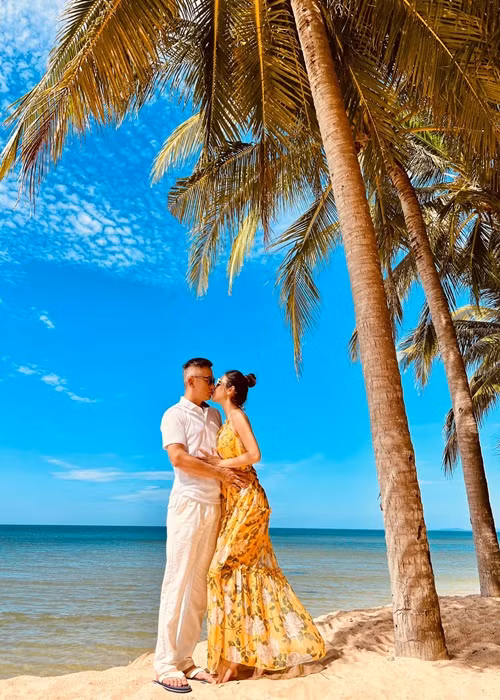 Vợ chồng Jennifer Phạm hôn nhau say đắm trên bãi biển.