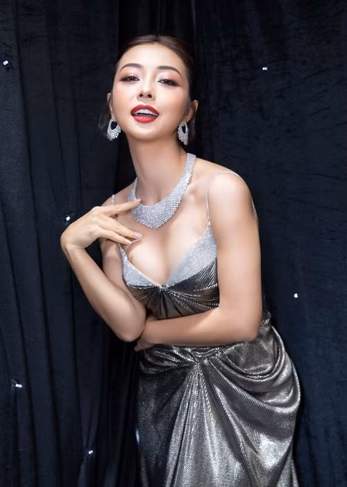 Jennifer Phạm phối bộ đầm gam màu ánh nhũ với vòng cổ, hoa tai trắng.