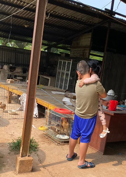 Bé Cà Pháo hết bồng bế em gái lại chở em gái cùng mẹ khác cha trên xe đạp.