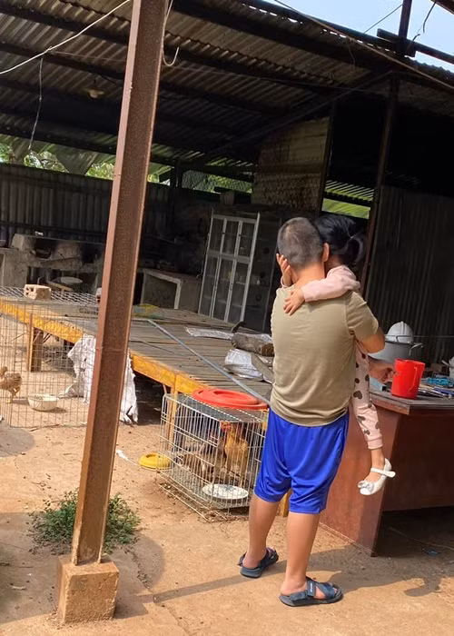 Bé Cà Pháo hết bồng bế em gái lại chở em gái cùng mẹ khác cha trên xe đạp.