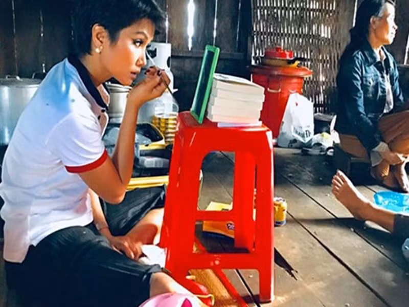 H'hen Niê còn gây bão khi ngồi bệt trên sàn nhà tự trang điểm với chiếc gương nhỏ đặt trên chiếc ghế nhựa. Ảnh: Saostar