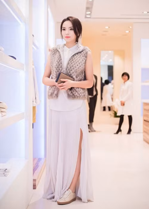 Chân dài sinh năm 1996 phối áo sơ mi buông thõng với áo gile, chân váy xẻ, đi giày sneaker màu trắng. Set đồ không hề có một chút liên quan nào với nhau. Ảnh: Dân Việt