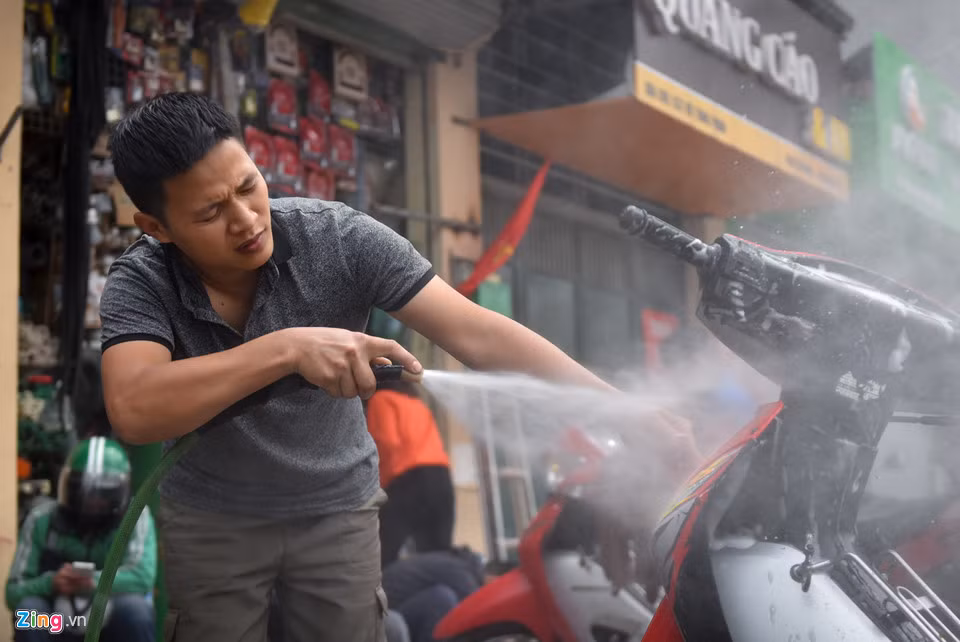 Hàng rửa xe máy của anh Đức Huy trên đường Vũ Tông Phan tăng từ 20 chiếc ngày thường lên 200 chiếc vào ngày giáp Tết. Giá tại đây ngày 29 Tết là 30.000 đồng/chiếc. Anh dự kiến tăng giá lên 50.000 đồng vào ngày mai.