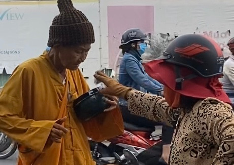 Lat tay nguoi phu nu gia su di xin tien de nuoi ban trai