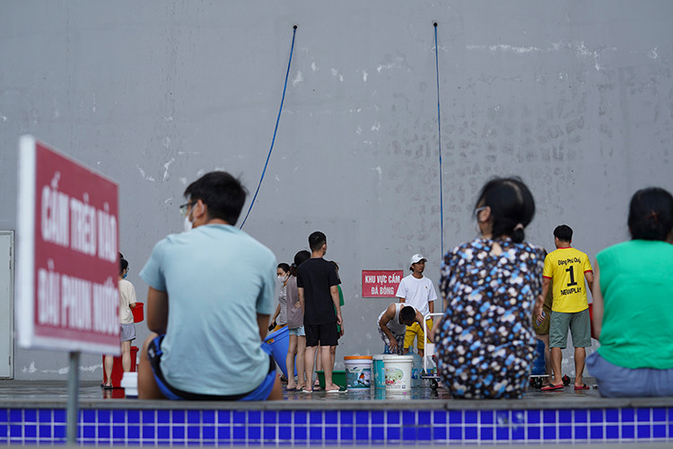 Cư dân chung cư Hateco Apollo Xuân Phương xếp hàng xách nước. "Tôi phải ngồi đợi gần 30 phút mới lấy được 2 xô nước khoảng 40 lít, mất nước khổ lắm nếu không ngồi đợi như này tối con cháu về không có nước để sinh hoạt...", bà Đào Thị Lan sống tại khu chung cư Hateco nói.