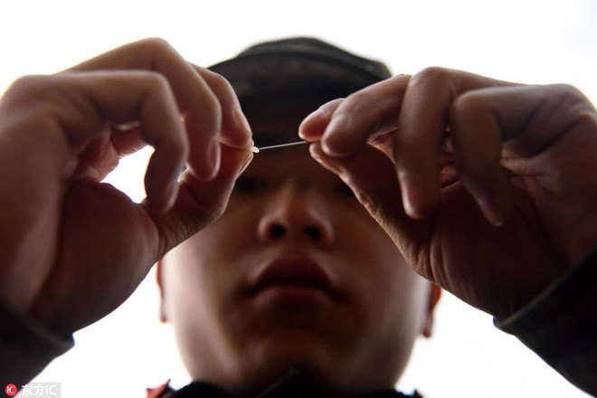 Xỏ kim qua hạt gạo, khoa mục này xem chừng có độ khó cao hơn nhiều so với cắm đầu que vào miệng ống hút, những bài tập trên được cho là có tác dụng luyện sự kiên nhẫn và tỉ mỉ cho quân nhân.