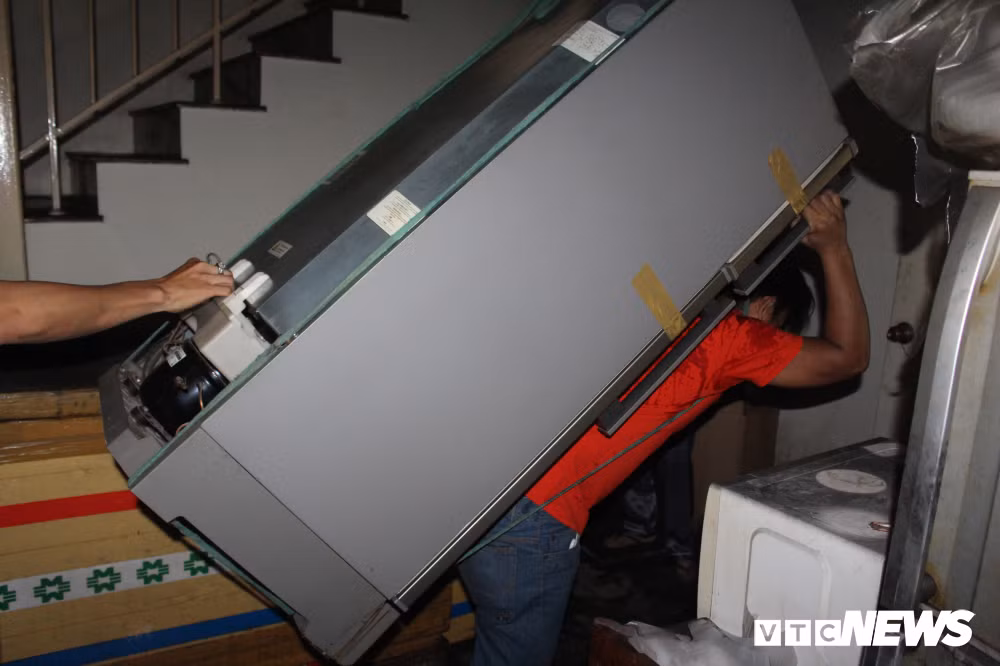 Còn bà Trương Thị Minh Khánh (sống ở tầng 1 chung cư) cho biết: “Vụ cháy đã hủy hoại nhiều tài sản trong quán tạp hóa của tôi. Chồng tôi cũng bị gãy chân đang được cấp cứu tại Bệnh viện An Bình. Do quá nhiều đồ đạc trong nhà nên tôi phải nhờ người thân, thuê xe ba gác, mỗi chuyến mất 300 nghìn đồng". Trong ảnh, bà Trương Thị Minh Khánh nhờ người thân khuân vác, đưa tủ lạnh từ tầng 1 ra ngoài.