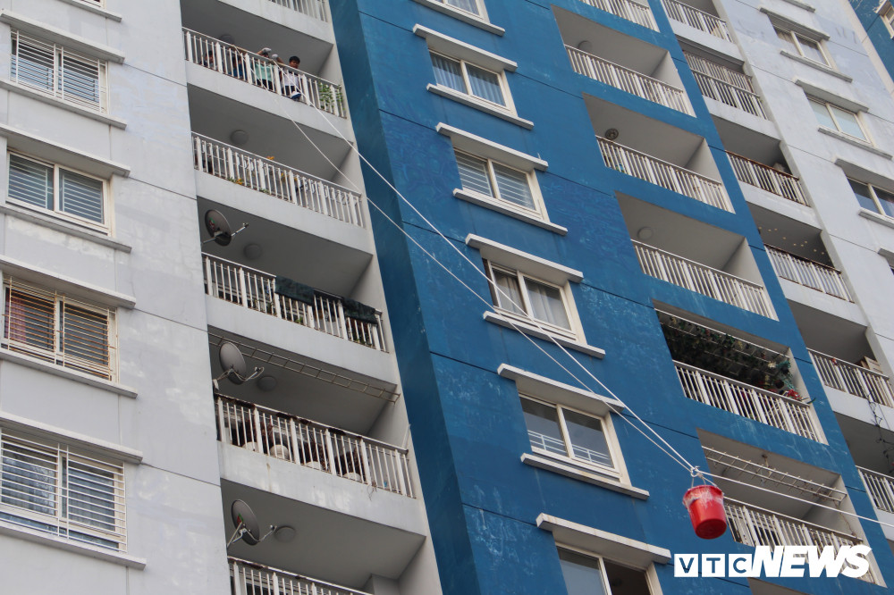 Sáng 28/3, cư dân sống tại chung cư Carina Plaza (phường 16, quận 8, TP.HCM) tất bật đưa những đồ đạc trong nhà ra ngoài để chủ đầu tư sửa chữa, tân trang lại nhà sau vụ cháy khủng khiếp khiến 13 người chết và hàng chục người bị thương. Ảnh: Cư dân sống ở chung cư Carina Plaza vận chuyển đồ dùng trong nhà bằng ròng rọc dây.