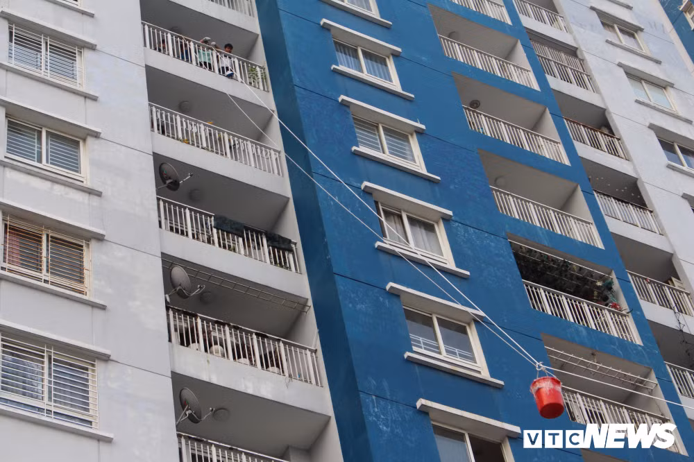 Sáng 28/3, cư dân sống tại chung cư Carina Plaza (phường 16, quận 8, TP.HCM) tất bật đưa những đồ đạc trong nhà ra ngoài để chủ đầu tư sửa chữa, tân trang lại nhà sau vụ cháy khủng khiếp khiến 13 người chết và hàng chục người bị thương. Ảnh: Cư dân sống ở chung cư Carina Plaza vận chuyển đồ dùng trong nhà bằng ròng rọc dây.