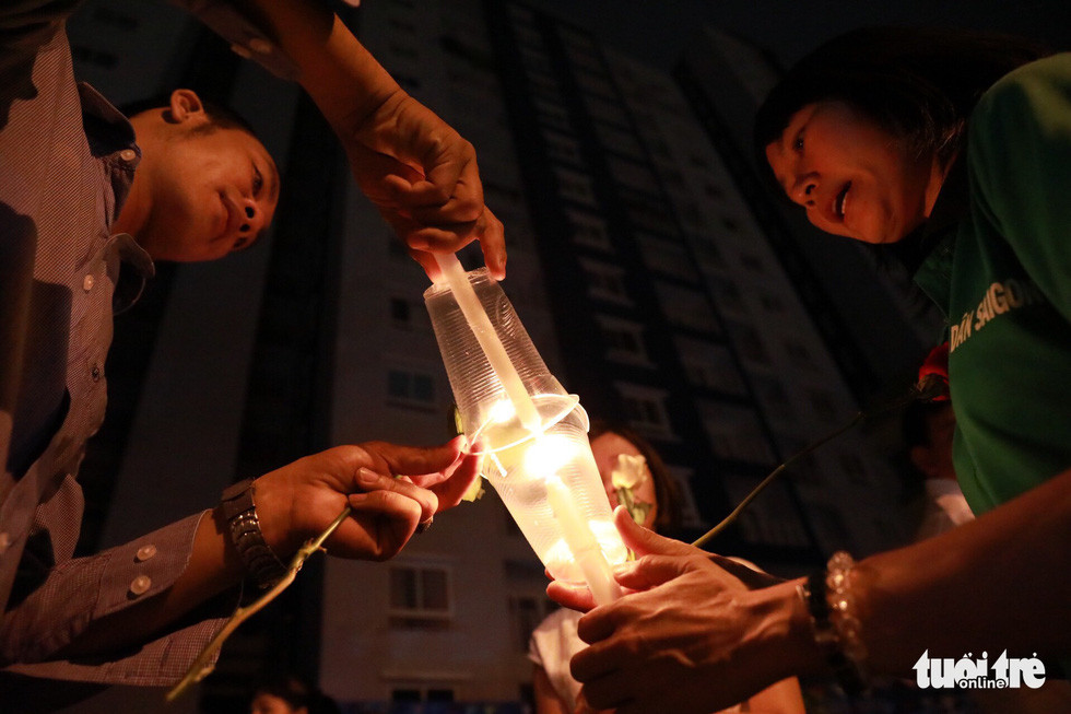 Bên cạnh nhóm người công giáo đứng thành hàng, những phật tử, cư dân theo đạo Phật tự bày biện trái cây, nhang khói... để mọi người tới thắp hương. Đây đó tiếng thút thít khóc xen lẫn tiếng cầu kinh, niệm phật...Ảnh: Người dân cùng nhau thắp nến để cầu nguyện cho các nạn nhân.